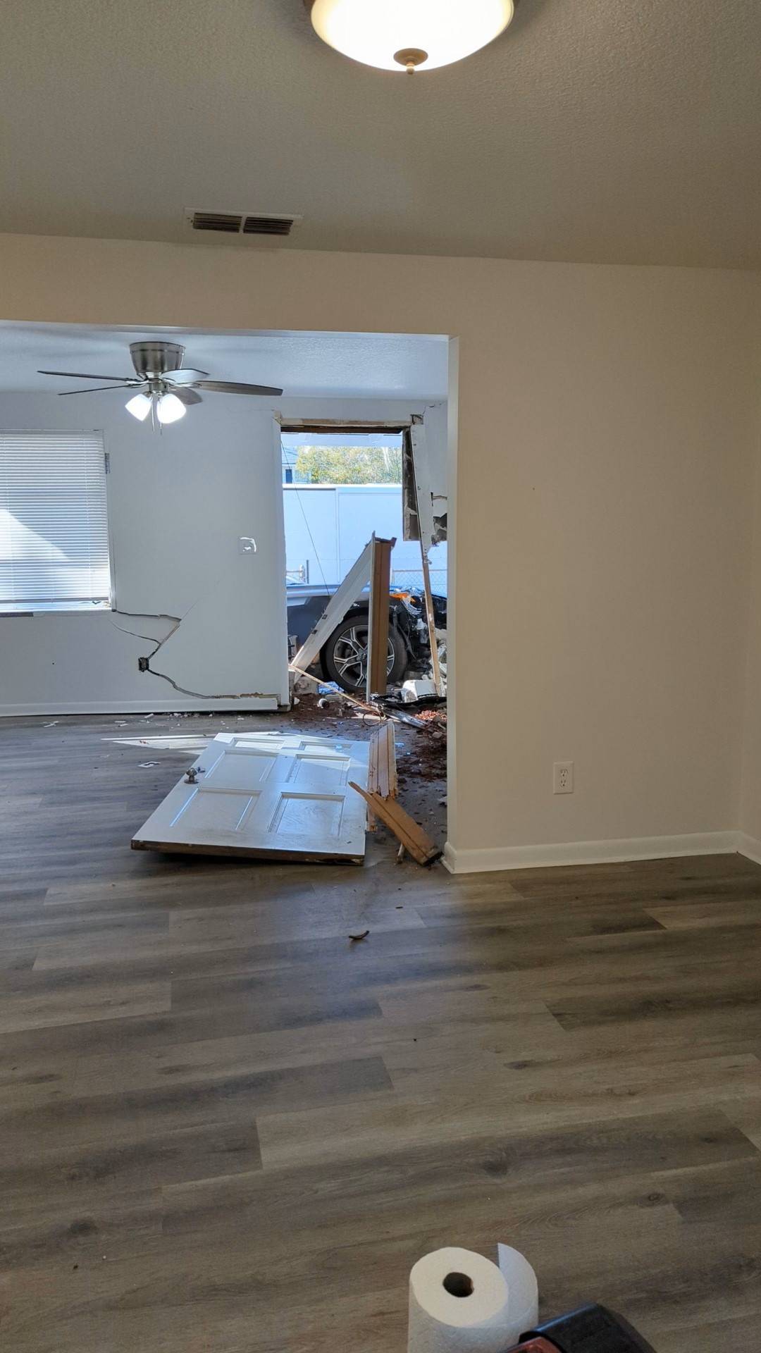 Inside the house after the crash: the front door off its hinges and the car through the wall.